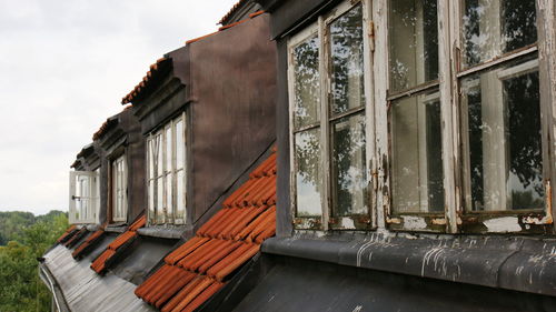 Low angle view of abandoned house against sky