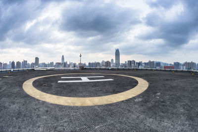 Text on road by buildings against sky in city