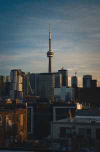 Modern buildings in city against sky at sunset