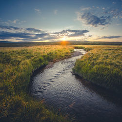 Scenic view of river against sky during sunset
