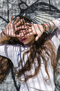 Young woman hiding face with hands while lying on concrete floor