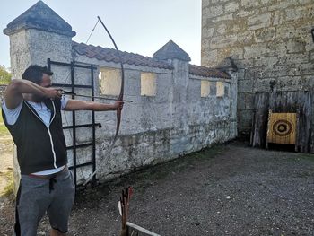 Side view of man standing against wall