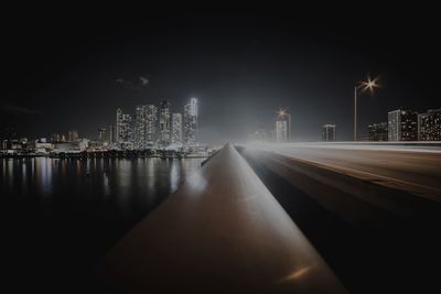 Illuminated city buildings against sky at night