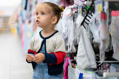 Full length of woman looking away while standing in store