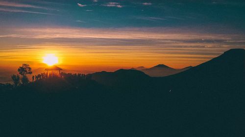 Scenic view of silhouette mountains against sky at sunset
