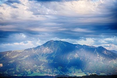 Scenic view of mountains against cloudy sky