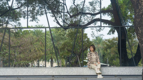 Rear view of woman standing against trees