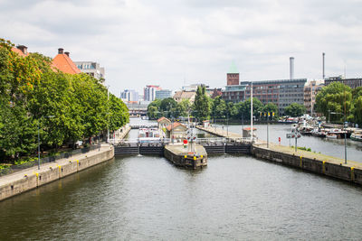 Bridge over river in city against sky