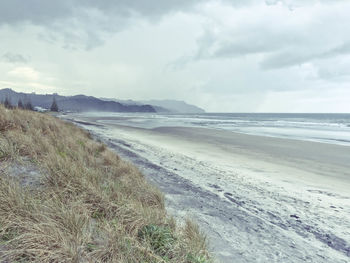 View of beach against cloudy sky