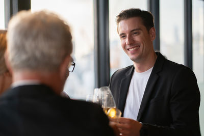 Portrait of a smiling young man drinking glass