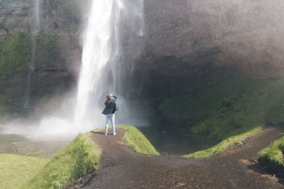 Full length of woman standing on rock formation