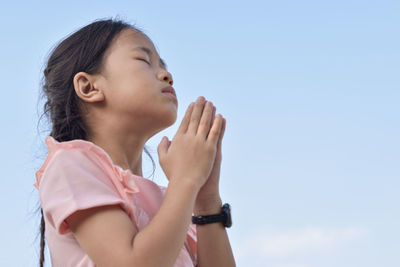 Low angle portrait of woman against sky