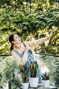 Young woman standing against trees