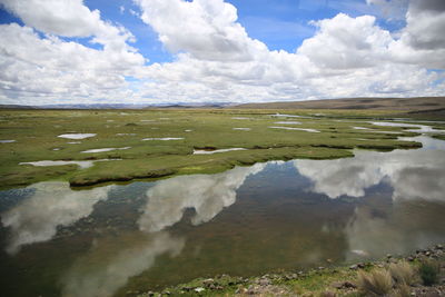 Scenic view of stream on landscape against sky