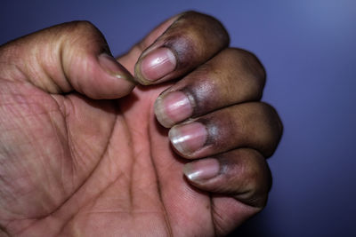 Close-up of human hand against blue background