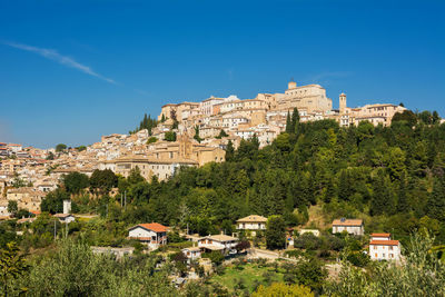 Buildings in city against clear blue sky