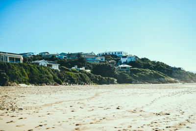 Scenic view of beach against clear blue sky