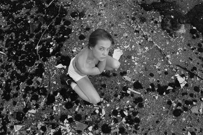 High angle portrait of woman crouching outdoors