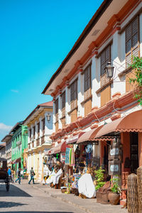 People on street amidst buildings in city