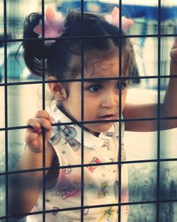 Portrait of cute girl holding window