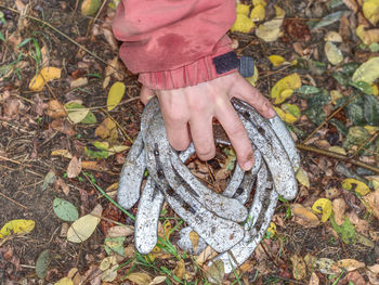 Worn horse shoes on palm of young woman in red jacket. obsolet horseshoes between fallen leaves