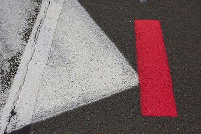 Red stripe and white rectangle  on asphalt. 