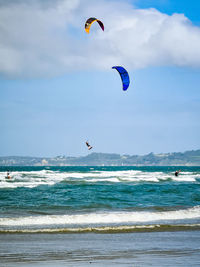 Kite boarder jumping in mid air over beach