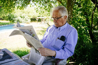 Midsection of man sitting in park