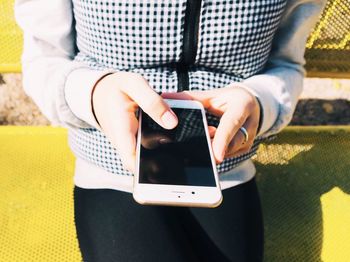 Midsection of man using mobile phone on table