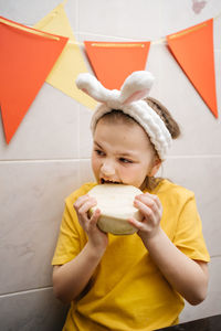 Girl in rabbit ears eat herb dill vegetables easter copy space. high quality photo