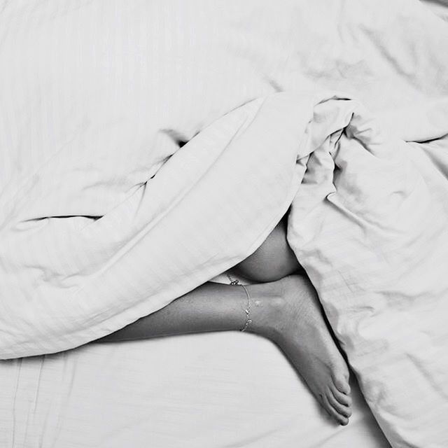 MIDSECTION OF WOMAN RESTING ON BED