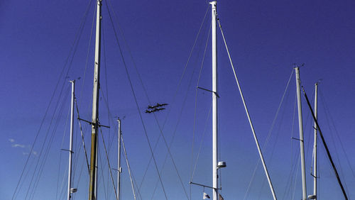 Low angle view of sailboat against clear blue sky
