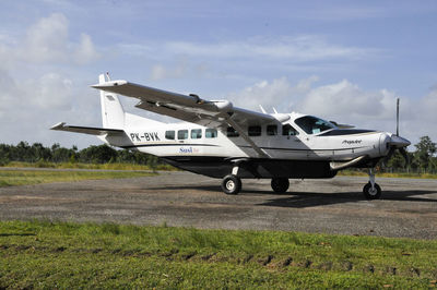 Airplane on airport runway against sky