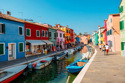 Boats moored in canal against buildings in city