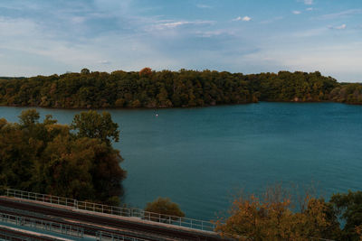 High angle view of trees by lake against sky