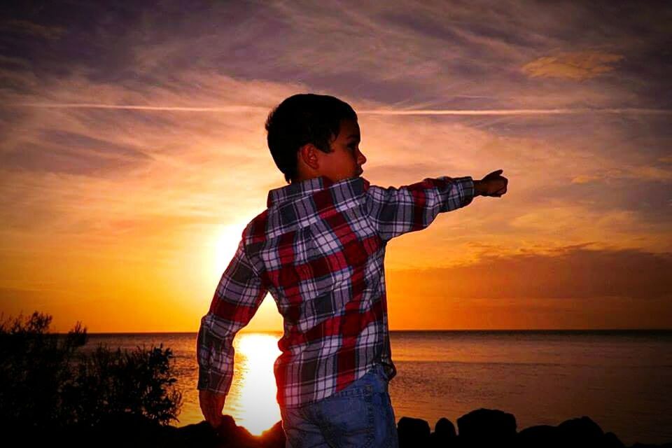 BOY LOOKING AT SUNSET SKY