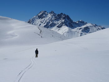 Person on snowcapped mountain against sky