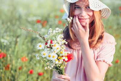 Portrait of a beautiful young woman with red flower