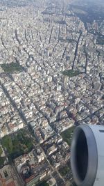 High angle view of airplane flying over cityscape