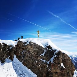 Low angle view of snowcapped mountain against blue sky