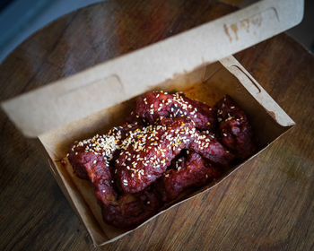 Spicy korean fried chicken wings and drummets in a take away box. traditional asian recipe.