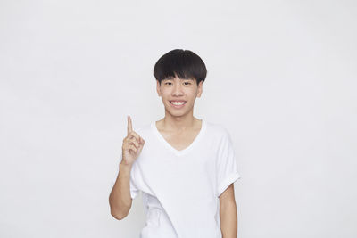 Portrait of smiling man standing against white background