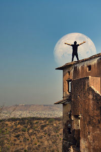 Side view of man standing against clear sky