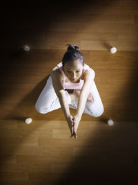 Directly above shot of woman practicing yoga on hardwood floor