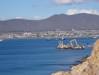 Scenic view of sea and mountains against sky