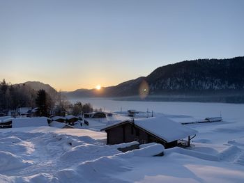 Scenic view of snow covered mountains against clear sky during sunset