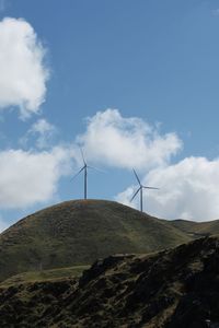 Wind turbines on land against sky