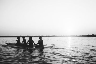 People enjoying in sea against sky