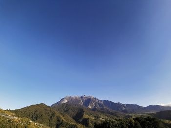 Scenic view of mountains against clear blue sky