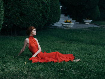 Rear view of woman sitting on field